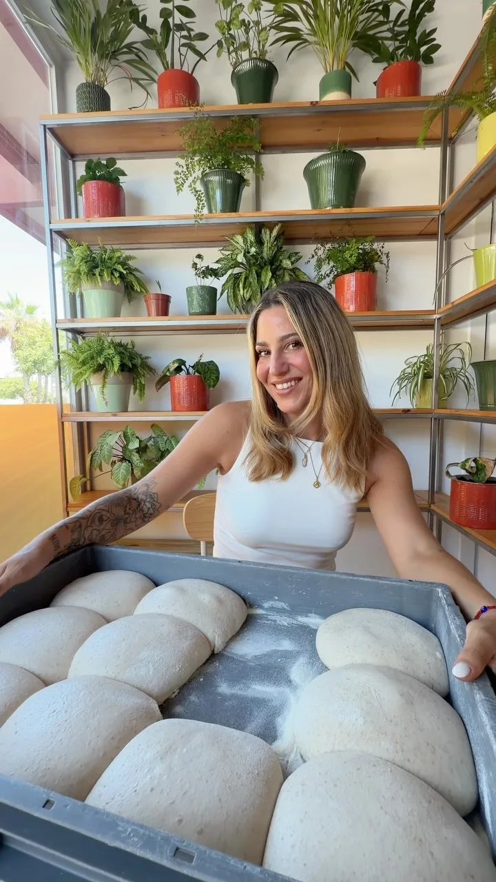 Masa madre activa en un recipiente de cristal en la cocina de Pizzeria Primavera, con textura esponjosa y burbujas visibles en la superficie